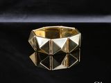 gros plan d'une bague en or sur une surface noire