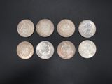 a group of six silver coins sitting on top of a black surface