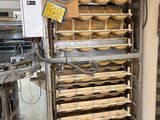 an image of a kitchen with a bunch of trays of food on a cart
