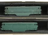 deux wagons verts dans une boîte posée sur une surface blanche