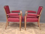pair of red upholstered armchairs with wood legs and arms