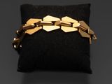 un bracelet en or posé sur un coussin noir