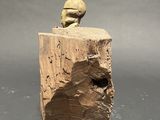 a close up of a sculpture of a person sitting on a tree stump