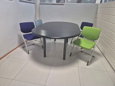 a table and chairs in a room with a white wall