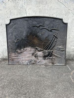 une plaque métallique représentant un bateau, posée sur le trottoir