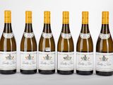 six bouteilles de vin sont alignées sur une table