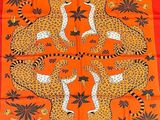 une écharpe orange ornée de léopards et de feuilles