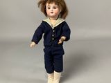 an image of a doll of a boy in a sailor suit