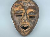 gros plan d'un masque en bois sur une surface blanche