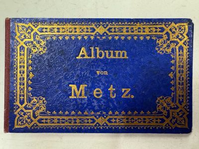 un livre bleu avec des inscriptions dorées, posé sur une table