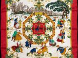 a close up of a red and yellow scarf with a picture of people playing in the snow