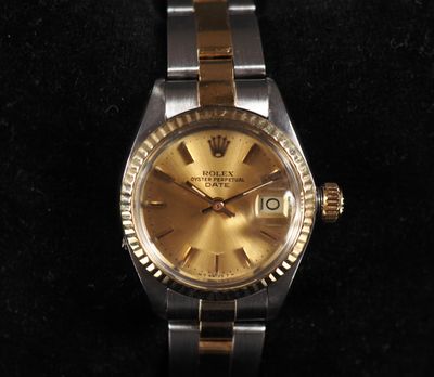 an image of a gold and silver watch on a black surface