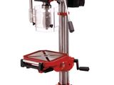 a red drill machine sitting on top of a metal stand