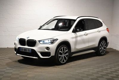 the white bmw suv is parked in a white room