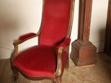 une chaise rouge placée devant une horloge