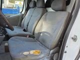 the interior of a white van with grey seats and a steering wheel
