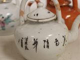 three teapots sitting on a table with chinese writing on them