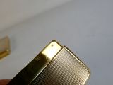 une personne tenant un briquet en or à la main