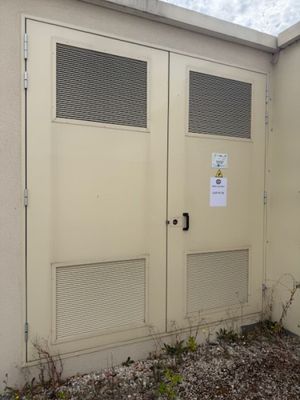 two doors on the side of a building that has a sign on it