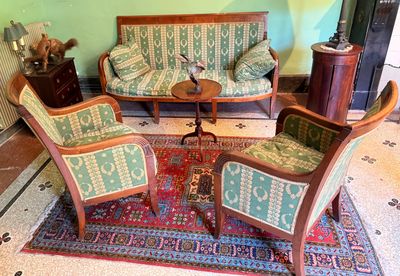 three chairs and a couch in a room with a rug