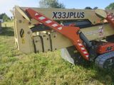 a picture of a small construction vehicle parked in the grass