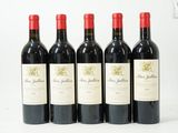 quatre bouteilles de vin rouge sont alignées sur une surface blanche