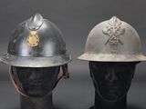 pair of firemen ' s helmets on mannequin heads against a gray background
