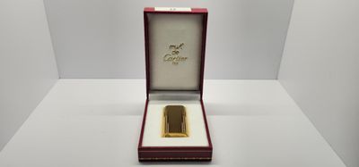 une pièce plaquée or dans un coffret rouge posé sur un fond blanc