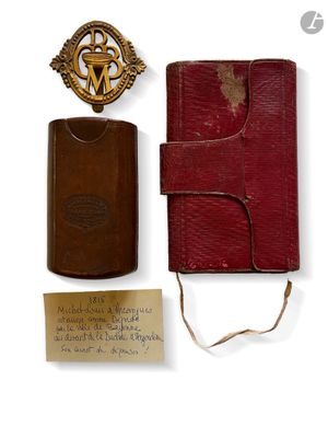 un vieux livre avec un insigne et un marque-page à côté
