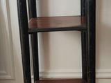 une petite table avec une étagère dans un coin de la pièce