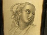 an old drawing of a woman ' s face in a black frame