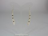 silver earrings with brown stones on them on a clear stand