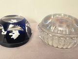 two glass dishes sitting on a table next to each other