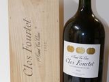 a bottle of red wine next to a wooden box