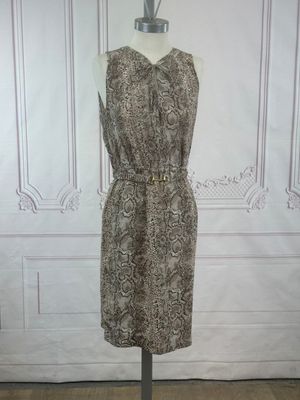 La robe est posée sur un présentoir à mannequin devant un mur blanc.