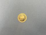 gros plan d'une pièce d'or sur une surface grise