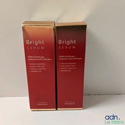 Deux boîtes de sérum aux couleurs vives sont posées sur une surface blanche