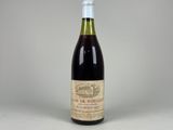 une bouteille de vin posée sur une table blanche