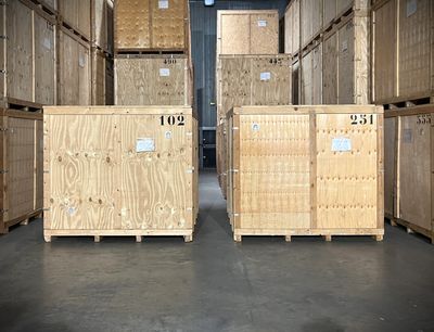 many wooden boxes that are stacked up in a warehouse