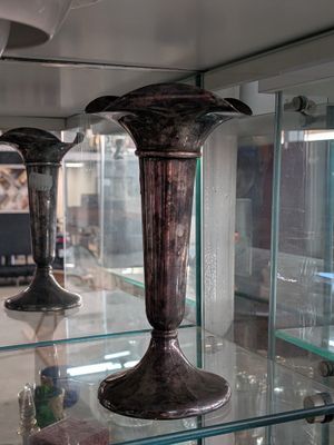 three vases on display in a glass case