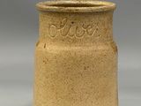 a close up of a brown vase on a gray surface
