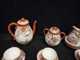 five pieces of tea and coffee set on a black table