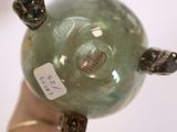 someone is holding a green glass vase with a tag on it