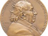 an image of a gold medal with a man ' s face on it