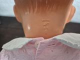 a close up of a doll ' s head with a pink shirt on