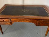 un bureau ancien avec un plateau en cuir et des tiroirs