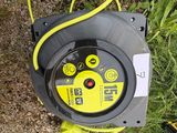 a yellow and black hose on the ground next to a pair of shoes