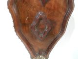 une horloge en bois en forme de cœur sur un support sur une surface blanche