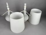 three white vases sitting next to each other on a table