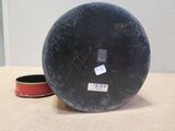 a black bowl sitting on a table next to a red bowl